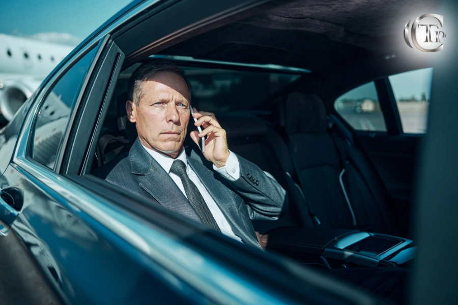 Business executive in a Mercedes chauffeured car making a call after landing at a private jet terminal.