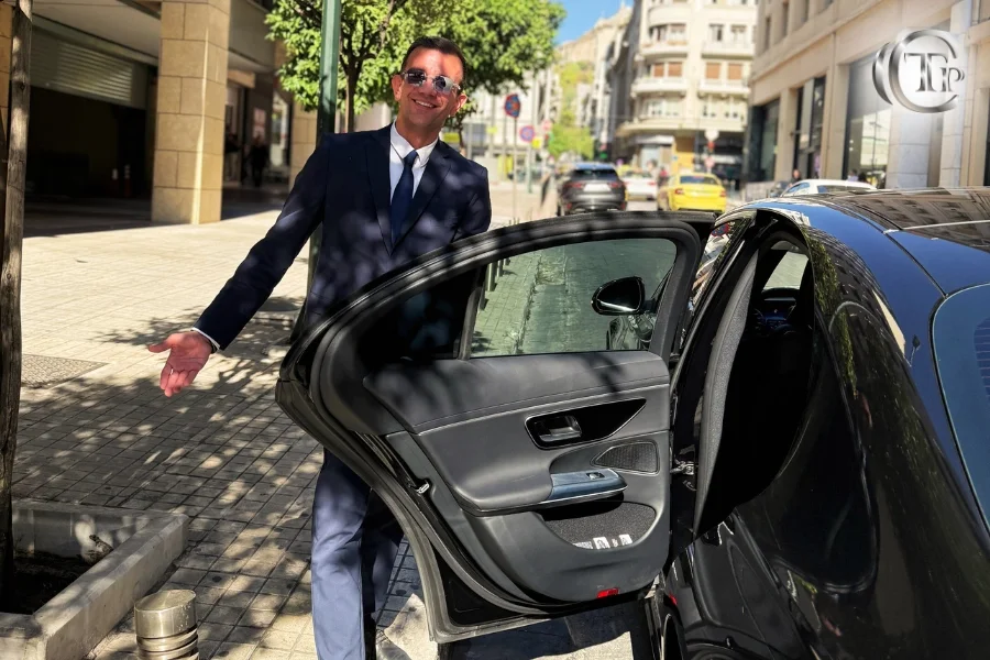 Οδηγός της CTP Limo ανοίγει την πόρτα Mercedes στο κέντρο της Αθήνας.